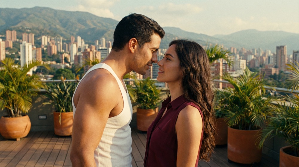Lucas and Isabela standing very close on office rooftop terrace, Medellín mountains in background, intimate body language, golden hour.